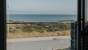 Vista desde un balcón sobre el mar, con cielo despejado y horizonte lejano.
