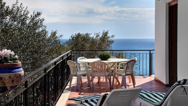 A balcony with a table and chairs, overlooking the sea. - Matisse Cantone (Massa Lubrense)