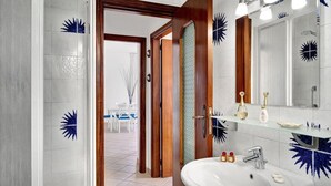 A bathroom with a white sink, a mirror, and a shower. - Matisse Cantone (Massa Lubrense)