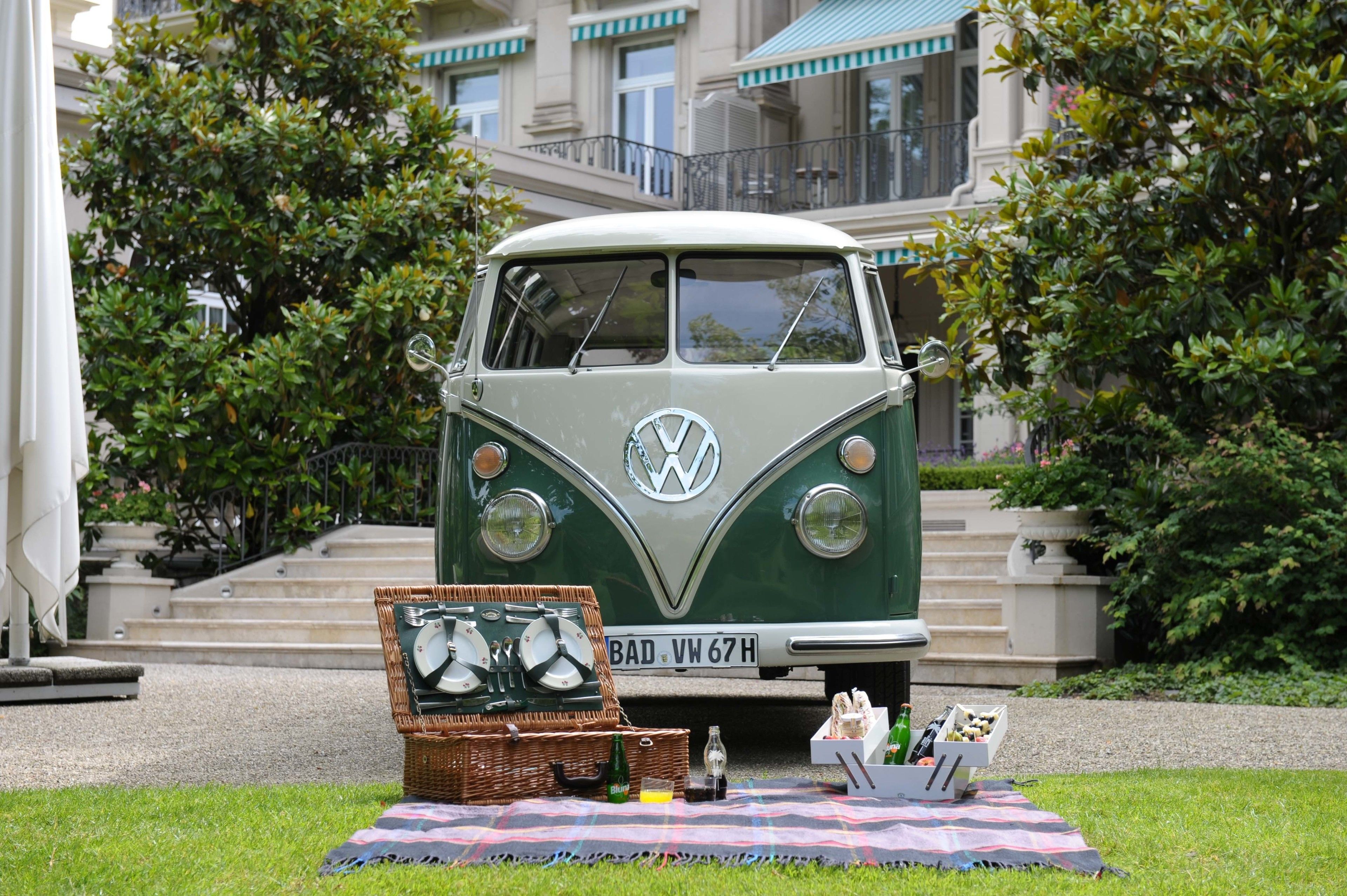 A vintage VW camper parked in front of a building with steps leading up to a balcony.