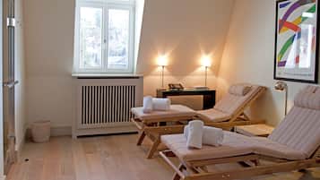Relax in this serene spa room with two loungers, a telephone, and a selection of books.