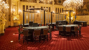 Una habitació opulent amb ostentosos lluminàries, una catifa vermella i una zona de bar.