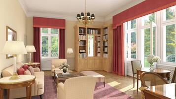 Ein geräumiges Wohnzimmer mit einer großen Bücherwand, einem bequemen Sofa, einem Couchtisch und einem Essbereich mit Stühlen.