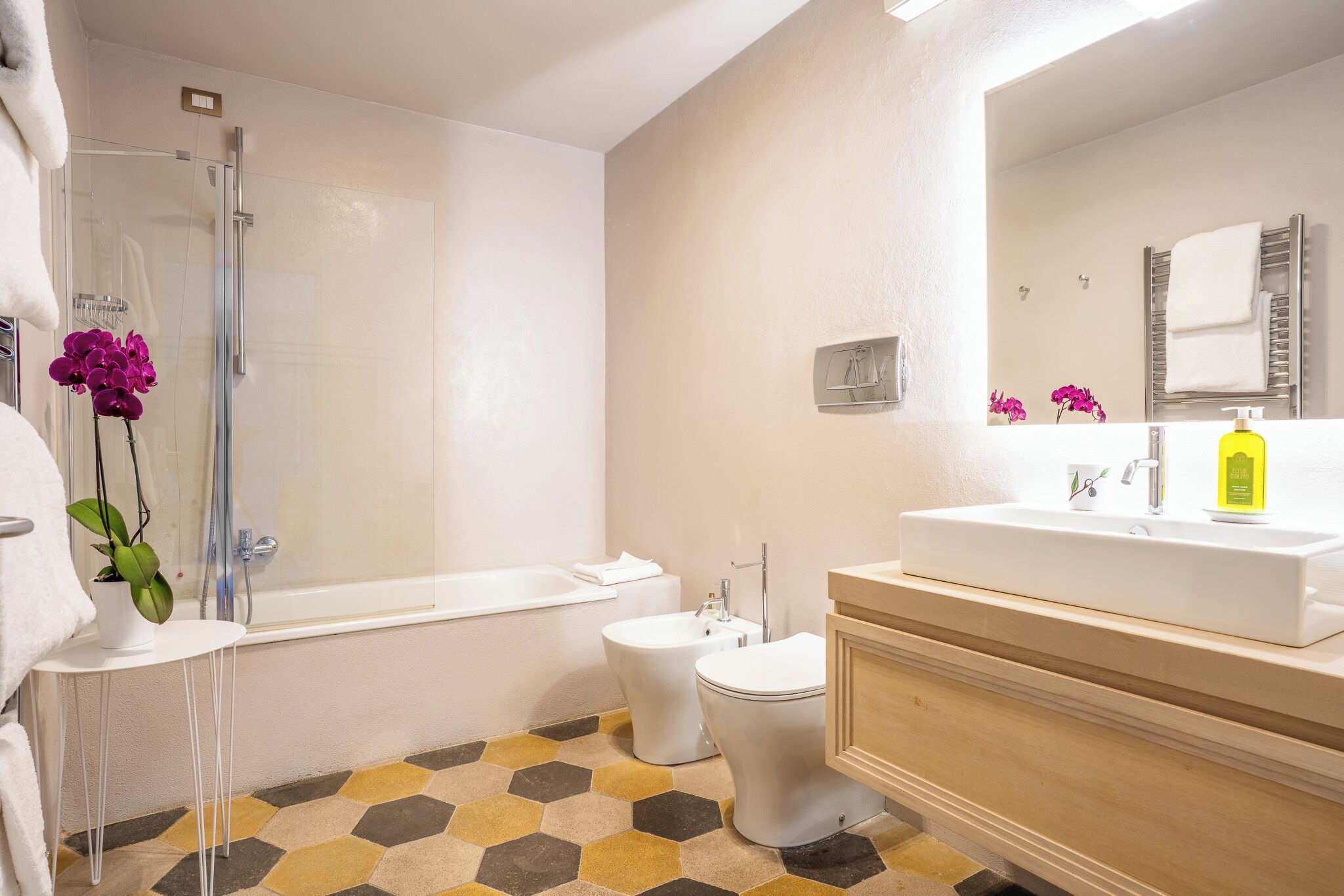 Un baño con ducha, inodoro, bidé y lavamanos.