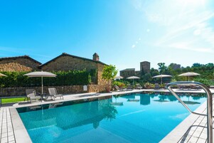 Una piscina al aire libre de temporada, sombrillas