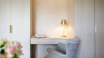 A modern desk with a lamp, a chair, and a book on the desk.