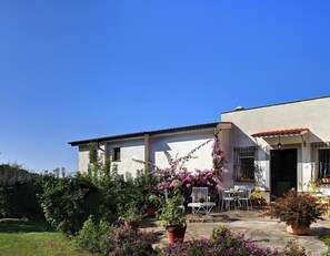 A modern house with a patio area featuring outdoor furniture and potted plants. - Casa Turiello (Massa Lubrense)