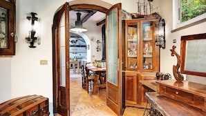 Una cocina tradicional con armarios de madera, una mesa de comedor y una máquina de coser antigua.