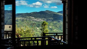 Vista desde un balcón sobre un paisaje montañoso con cielo despejado.
