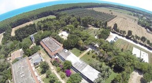 Vue aérienne d’une propriété comprenant un grand bâtiment, de nombreux champs et de vastes zones boisées.