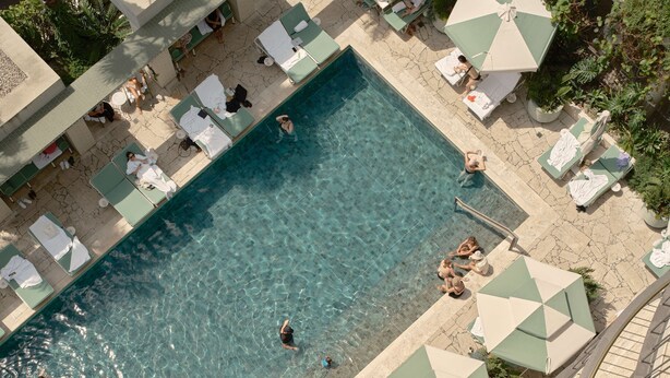 An aerial view of a swimming pool area with lounge chairs and umbrellas. - The Calile Hotel (Fortitude Valley)