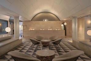 A lobby with a reception desk, seating area, and a check-in counter. - The Calile Hotel (Fortitude Valley)