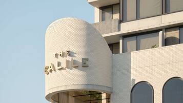 A modern building with a cylindrical section labeled "THE SLOPE." It features a brick facade, multiple balconies, and large windows.