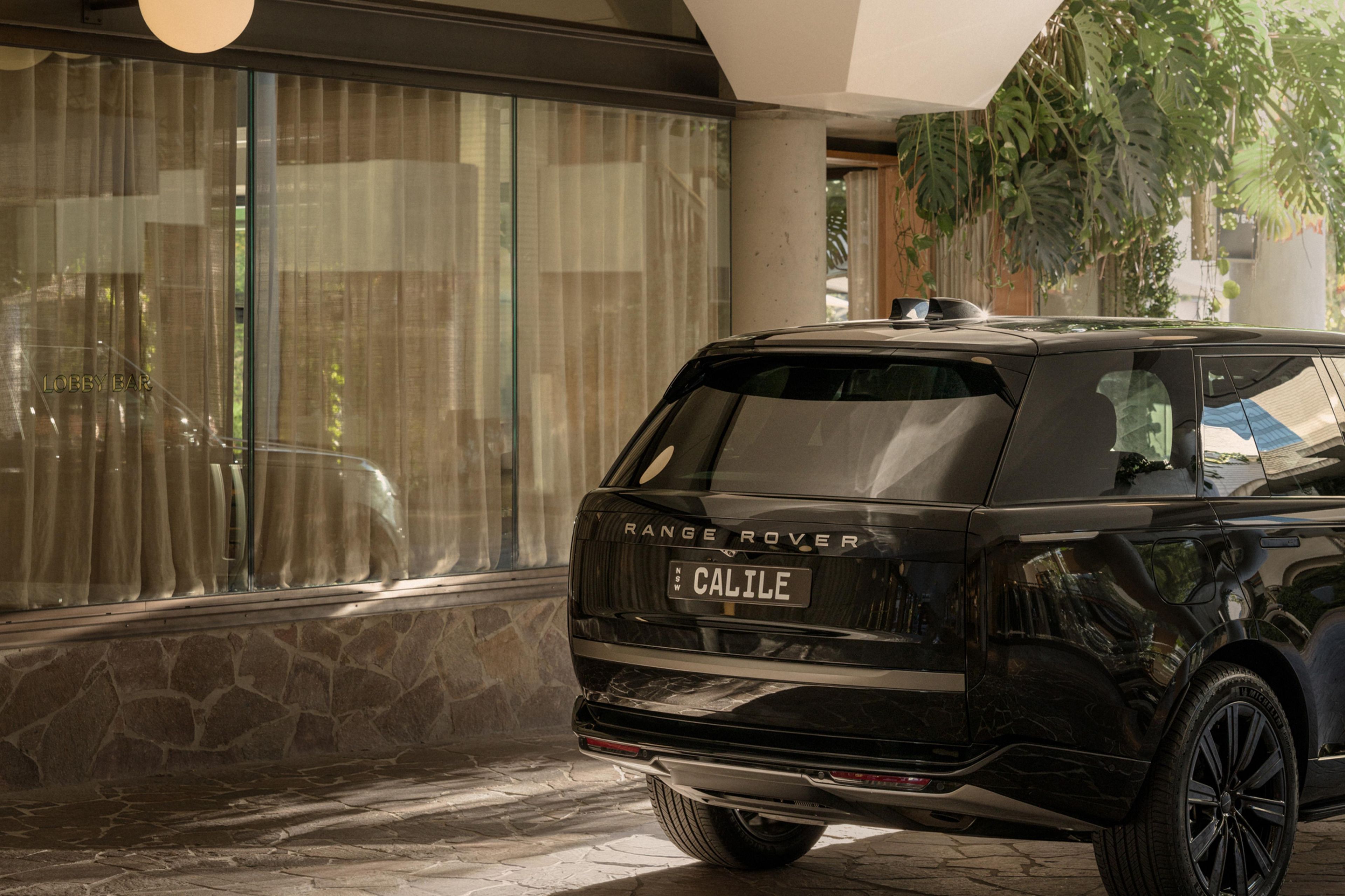 A black Range Rover with a license plate 'CALILE' parked in a driveway.