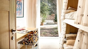 A bedroom with a wooden desk, a chair, and a bed with curtains. - Villa Bougainvillea (Capri)