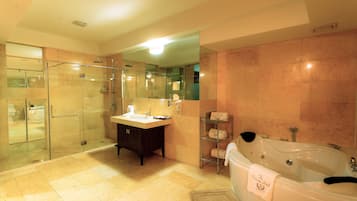 A modern bathroom with a glass-enclosed shower, a vanity with a mirror, and a large bathtub with a towel.