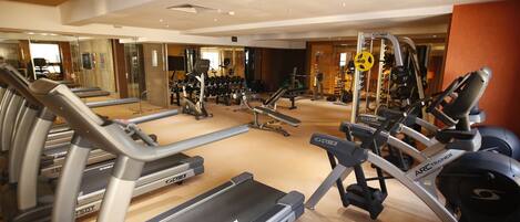 A gym with treadmills, elliptical machines, and weight equipment.