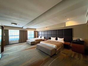 Una habitación de hotel con dos camas, un ventanal grande y vistas a la ciudad.