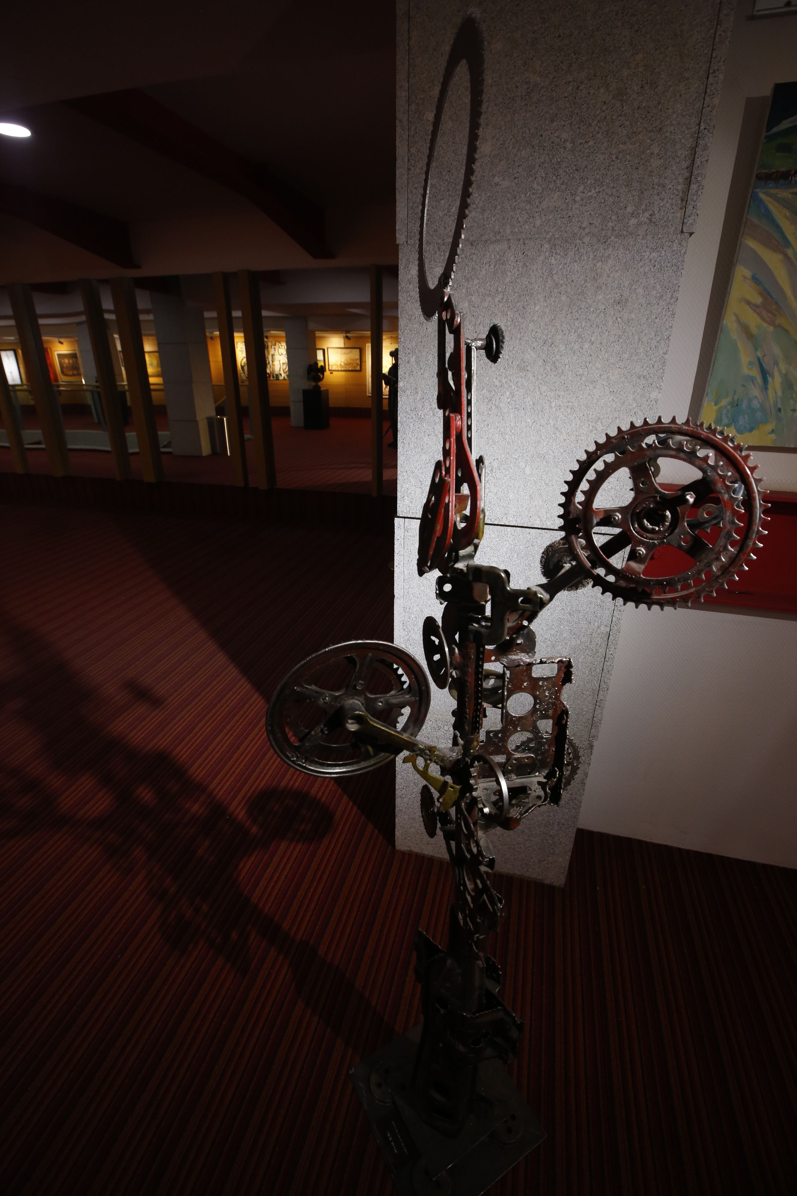 A wall-mounted sculpture of a bicycle with gears and a chain.