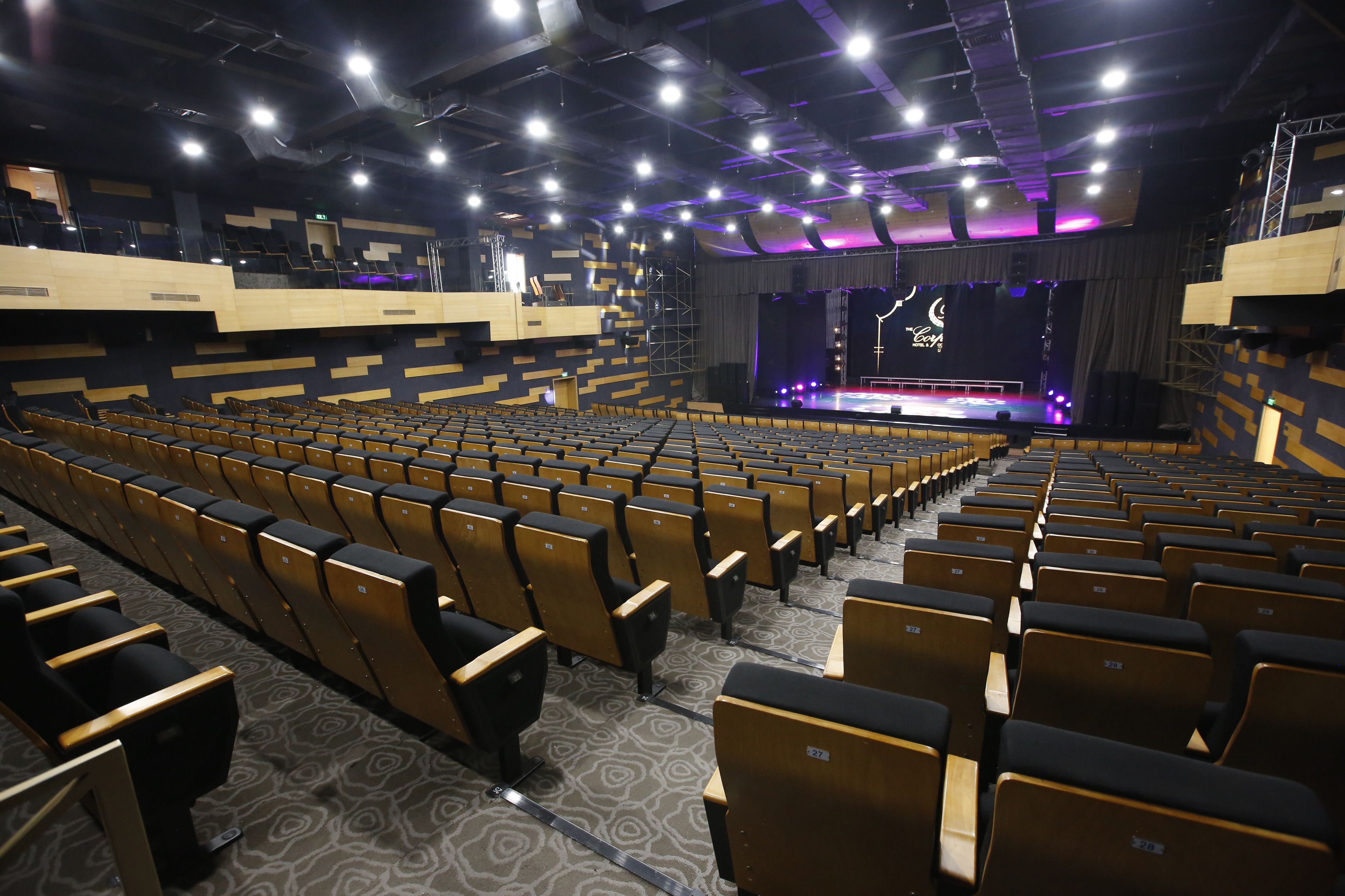 Un teatro con hileras de asientos, un escenario y un balcón.