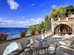 A seaside terrace with outdoor seating, a view of the sea, and potted plants. - Vera e il Vervece (Massa Lubrense)