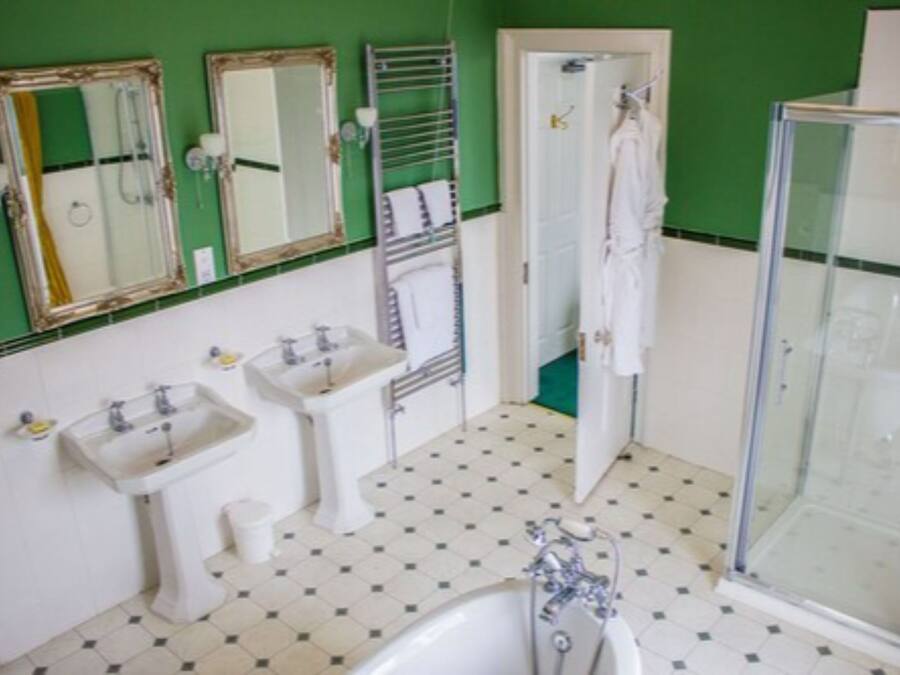 A bathroom with two sinks, a bathtub, a shower, and three mirrors.