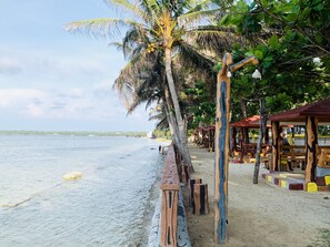 Una playa con estructuras de madera y bancos a lo largo de la orilla.