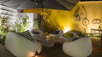 Relax in a shaded outdoor space with a table and four chairs, surrounded by lush greenery.