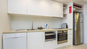 A modern kitchen with white cabinets, stainless steel appliances, and a dishwasher.