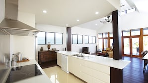 Een moderne keuken met een centraal eiland, een ingebouwde vaatwasser en een groot raam dat voor natuurlijk licht zorgt.