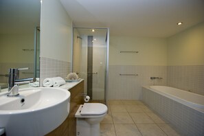 A modern bathroom with a sink, toilet, and bathtub.