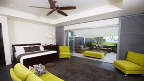 Un dormitorio moderno con cama, sofá y balcón con mobiliario exterior.