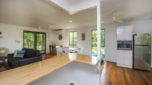 Una cocina moderna con una isla central, armarios blancos y un microondas integrado.