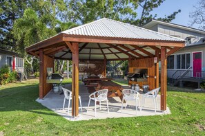 Relax in a serene outdoor space with a barbecue grill and comfortable seating.