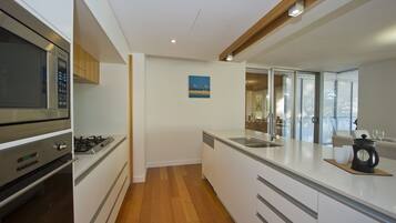 Apartamento superior, 3 quartos, acesso à piscina, de frente para a praia | Cozinha privada | Geladeira grande, micro-ondas, fogão, cooktop