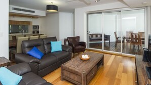 Una sala de estar moderna con sofá, una mesa de centro y un comedor con sillas.