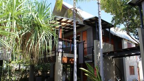 A two-story house with a balcony, surrounded by tropical plants. - Pure Magnetic Villa 8 (Nelly Bay)