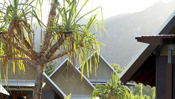 A sign for 'Pure Magnetic' with a modern building in the background. - Pure Magnetic Villa 8 (Nelly Bay)