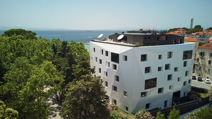 A modern building with multiple floors, satellite dishes, and a view of the sea. - Briig Boutique Hotel (Split)