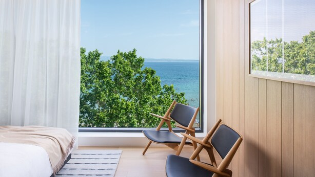 A bedroom with a large window, a bed, and two chairs. - Briig Boutique Hotel (Split)