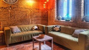 Une pièce chaleureuse avec deux canapés, une petite table et une horloge murale.