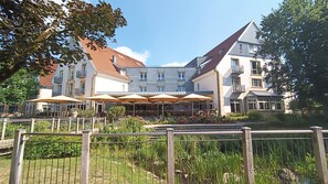 Un hotel con terraza y jardín.