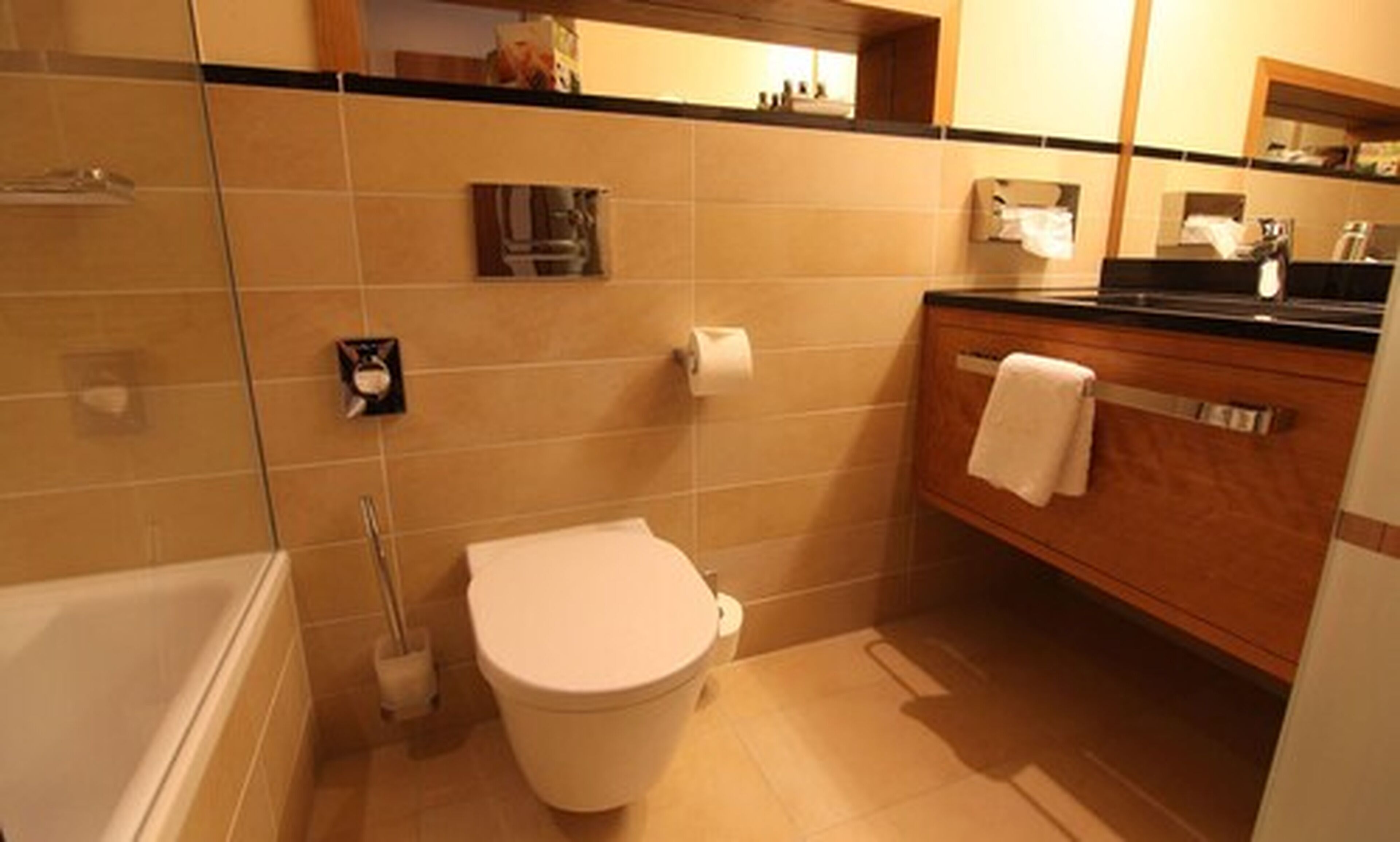 A bathroom with a toilet, a bidet, a towel rack, and a mirror.