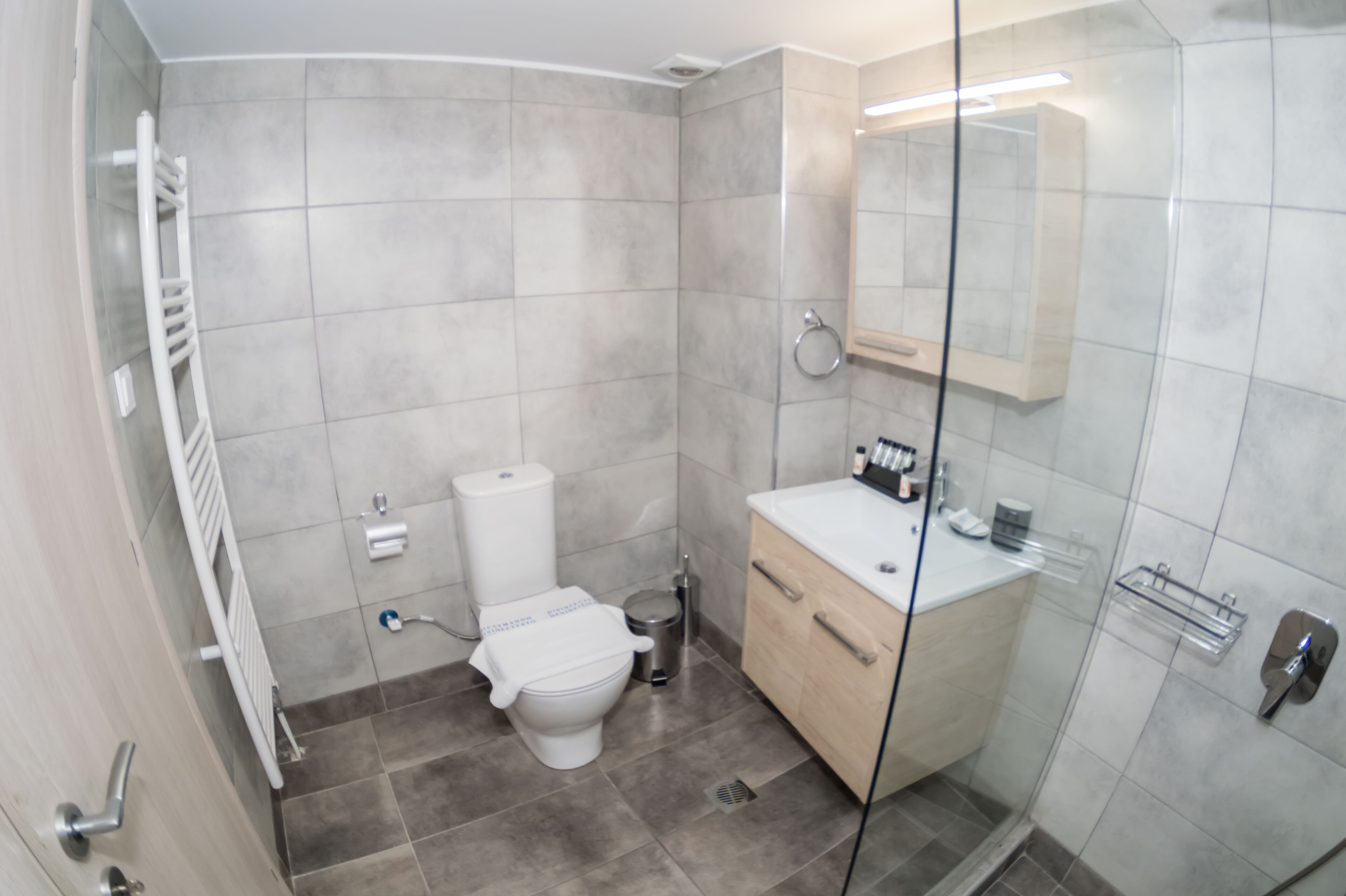 A modern bathroom with a toilet, sink, and shower area.