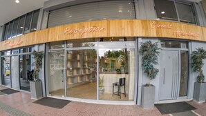 A reception area with a wooden facade, glass doors, and a reception desk. - Connect Studios & Apartments (Athens)