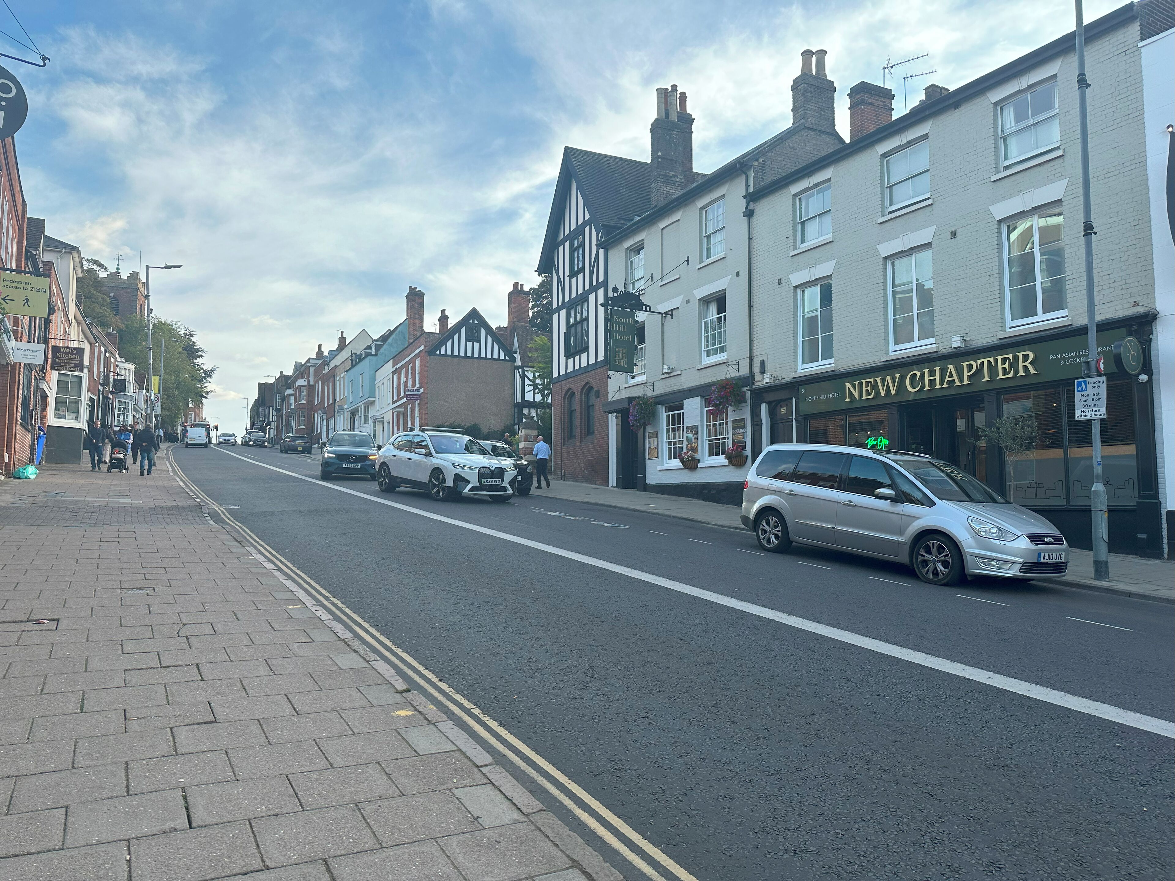 A street with buildings, including a restaurant named 'New Chapter'.