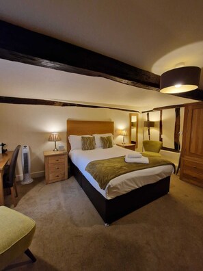 A bedroom with a large bed, bedside tables with lamps, a desk, a chair, and a wardrobe. - The North Hill Hotel, Colchester (Colchester)