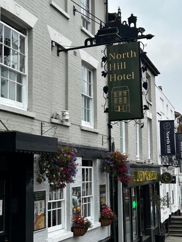 A building with a sign reading "North Hill Hotel" and a pub sign below it. - The North Hill Hotel, Colchester (Colchester)