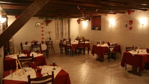 A dining area with round tables, red tablecloths, and wooden chairs. - Auberge Saint Martin (Saint-Martin-Terressus)