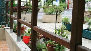 A wooden pergola with a tiled floor and potted plants. - Auberge Saint Martin (Saint-Martin-Terressus)